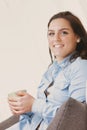 Smiling woman on white couch with drink