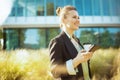 smiling woman worker in business district using smartphone Royalty Free Stock Photo