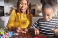 Smiling woman working with child on bead project