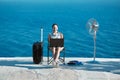 Smiling woman working on laptop on beach. Seascape on background. Life work balance and business travelling concept