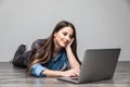 Smiling woman working on laptop on floor Royalty Free Stock Photo