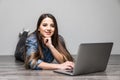 Smiling woman working on laptop on floor Royalty Free Stock Photo