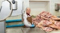 Smiling woman working on meat cutting band saw