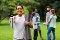 Smiling woman with yoga mat and bottle at park Royalty Free Stock Photo