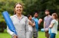 Smiling woman with yoga mat over group of people Royalty Free Stock Photo