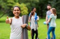 Smiling woman with yoga mat showing thumbs up Royalty Free Stock Photo