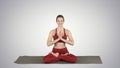 Smiling woman yoga meditating sitting lotus, hands coupled on gr