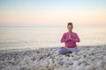 Smiling woman yoga meditation siddhasana lotus namaste hands sea sunset beach sky horizon landscape