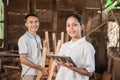 Smiling women entrepreneurs standing holding a tablet pc and workers standing behind