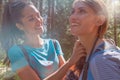 Smiling woman helping friend at hiking trail path in forest woods during sunny day.Group of friends people summer Royalty Free Stock Photo