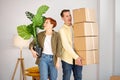 woman holding cardboard box relocating into new home with husband, couple first time real estate buyers renters