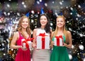 Smiling women in party caps with gift boxes