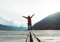 Smiling women relax and wearing red jacket standing on the wooden bridge over the lake. Travel and Vacation. Freedom Concept. Wood Royalty Free Stock Photo