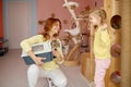 Smiling woman showing cat in cage to little bit scared cute girl child Royalty Free Stock Photo