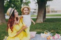 Smiling woman in yellow dress play in park, have fun and amuse with little cute child baby girl hold soap bubble blower Royalty Free Stock Photo