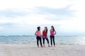 Smiling women yoga outdoor on the beach. Young athletic women friends with yoga mats background seashore.