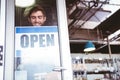 Smiling worker putting up open sign Royalty Free Stock Photo