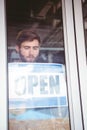 Smiling worker putting up open sign Royalty Free Stock Photo