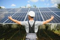 Smiling worker with solar station, raising his hands, showing thumbs up on a background of photovoltaic panels near the Royalty Free Stock Photo