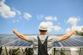 Smiling worker with solar station, raising his hands, showing thumbs up on a background of photovoltaic panels near the Royalty Free Stock Photo