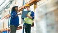 Smiling workers in distribution warehouse having a cheerful conversation Royalty Free Stock Photo