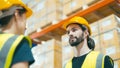 Smiling workers in distribution warehouse having a cheerful conversation Royalty Free Stock Photo