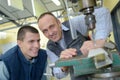 Smiling workers watching bench drill