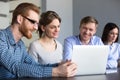 Smiling workers watching interesting video at laptop in office Royalty Free Stock Photo