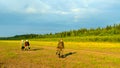 A smiling Yakut man walks ahead of two female friends chatting in the sun on the stone wild Bank of the Northern Viluy river Royalty Free Stock Photo