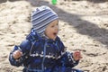A smiling 2-year- old boy playing in a sandbox Royalty Free Stock Photo