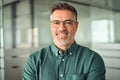 Smiling 45 years old business man wearing glasses in office, headshot portrait. Royalty Free Stock Photo