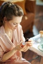 Smiling woman reading instruction on cosmetic elixir