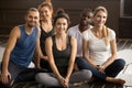 Yoga instructor posing with multiracial people at group training