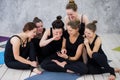 Smiling yogi girl exercising, having a break at class, group of friends watching on the phone Royalty Free Stock Photo