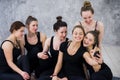 Smiling yogi girl exercising, having a break at class, group of friends watching on the phone Royalty Free Stock Photo