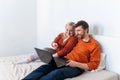 Young adult couple using laptop and laughing together Royalty Free Stock Photo