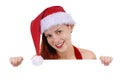 Smiling young adult woman in Christmas Santa hat holding plain white blank advertising board, copy space Royalty Free Stock Photo