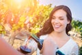 Smiling Young Adult Woman Enjoying Glass of Wine Tasting Pour In The Vineyard with Friends Royalty Free Stock Photo