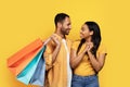 Smiling young african american boyfriend hugs woman, hold many packages with purchases, enjoy buy