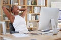 Smiling young african american businesswoman relaxing at her desk in front of her computer. Cheerful business Royalty Free Stock Photo