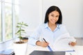 Smiling young african american businesswoman working on her desk in a bright modern office Royalty Free Stock Photo