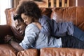 Smiling young African American father holding on back adorable happy daughter. Royalty Free Stock Photo