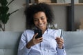 Smiling African American woman buy online on cellphone Royalty Free Stock Photo