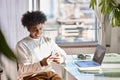 Smiling young African American guy using mobile phone at home. Royalty Free Stock Photo