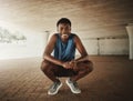 Portrait of a happy african american fitness young male runner crouching on pavement smiling and looking at camera Royalty Free Stock Photo