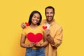 Smiling young african american lady and boyfriend holding hearts in hands, enjoy relationships Royalty Free Stock Photo