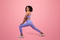 Smiling young african american lady in sportswear doing leg stretching exercise, enjoy sport