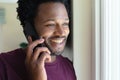 Smiling young african american man talking on mobile phone at home Royalty Free Stock Photo