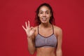 Smiling young african american sports fitness woman in sportswear posing working out isolated on red wall background Royalty Free Stock Photo