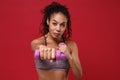 Smiling young african american sports fitness woman in sportswear working out isolated on red background in studio Royalty Free Stock Photo